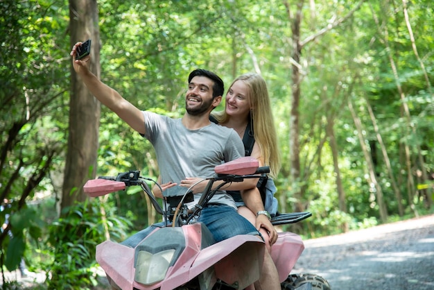 Hombre tomando selfie con novia mientras está de pie en ATV