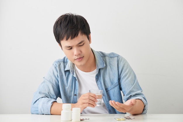 Hombre tomando sus pastillas en el sofá de la sala de estar