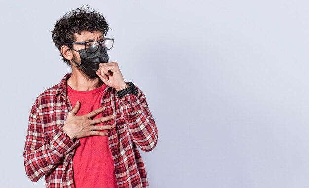 Hombre tosiendo con mascarilla quirúrgica brote de coronavirus concepto de distanciamiento social y problemas respiratorios