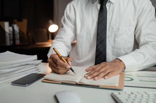 Un hombre trabaja horas extras en la oficina de una empresa nueva en medio de la noche, trabaja duro después del trabajo, empleado de la empresa horas extras Concepto de horas extras y trabajo duro