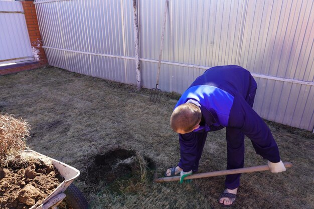 Foto un hombre trabaja en un huerto a principios de la primavera