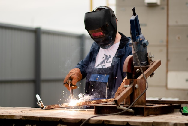 El hombre trabaja con una máquina de soldar Una rara profesión laboral