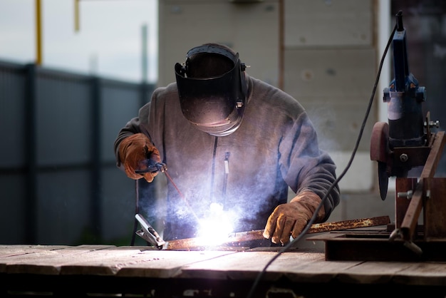 El hombre trabaja con una máquina de soldar Una rara profesión laboral