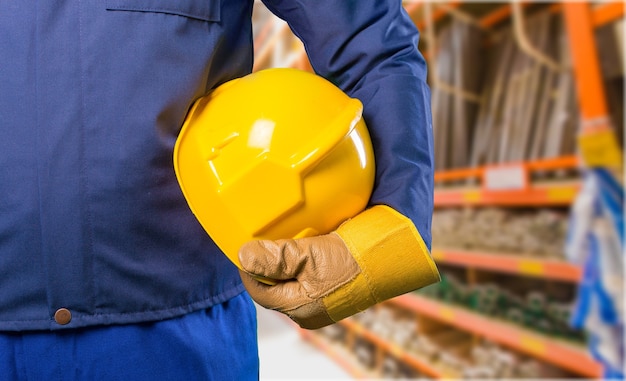 Hombre trabajador con casco en el fondo