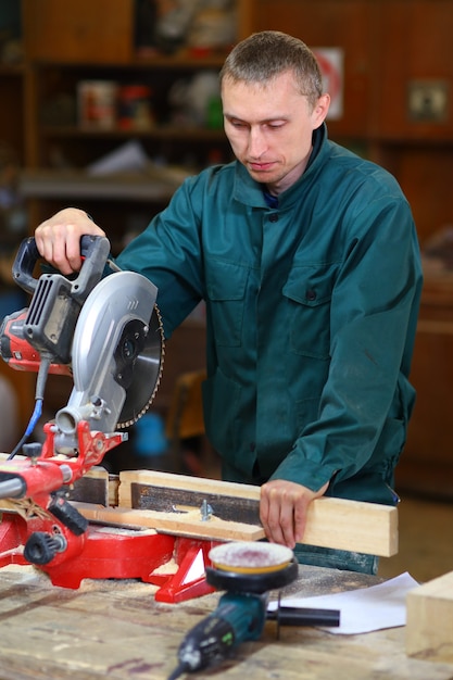 Hombre trabajador joven y guapo trabajando en máquina herramienta