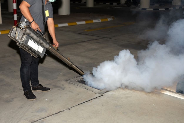 Hombre trabajador nebulizando insecticida para eliminar el mosquito y prevenir el dengue y el virus zika