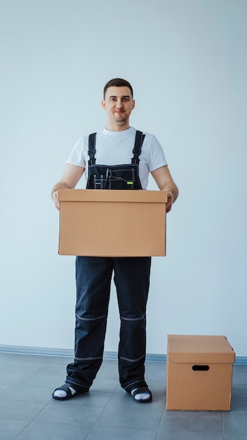 Hombre trabajador en traje de baño en la caja Mudanza a un nuevo apartamento