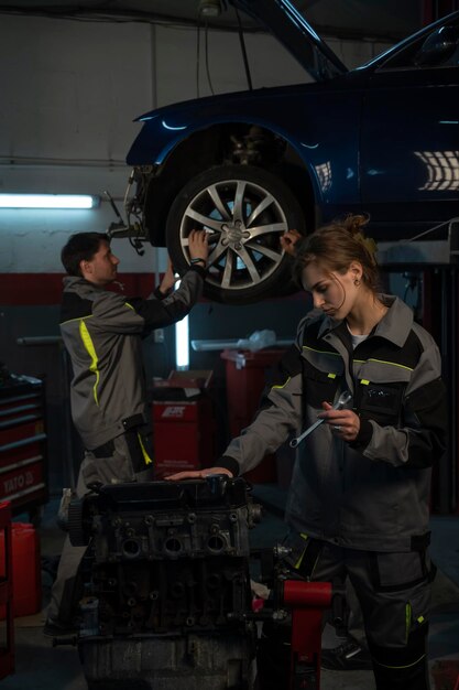 Foto un hombre está trabajando en un automóvil con una herramienta en la mano.