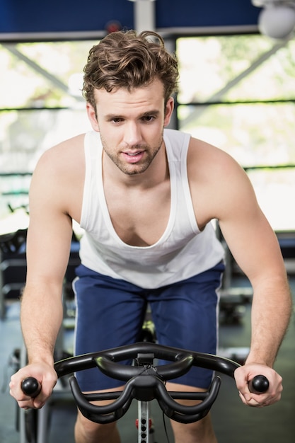 Hombre trabajando en bicicleta estática en la clase de spinning