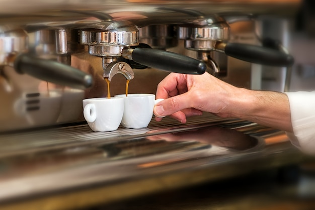 Hombre trabajando en una cafetería preparando espresso