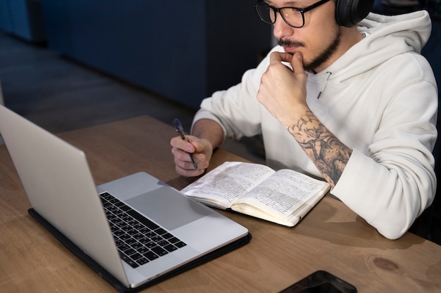 Hombre trabajando desde casa en un escritorio con un portátil