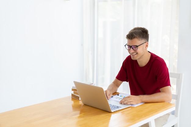 Hombre trabajando desde casa en la moderna sala blanca