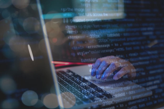 Hombre trabajando en una computadora portátil en la oscuridad