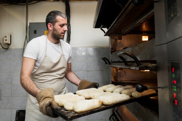 Foto hombre trabajando en deliciosos panes frescos