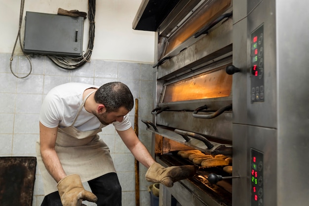 Foto hombre trabajando en deliciosos panes frescos