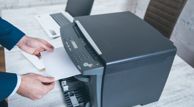 Hombre trabajando en dispositivo xerox en Office