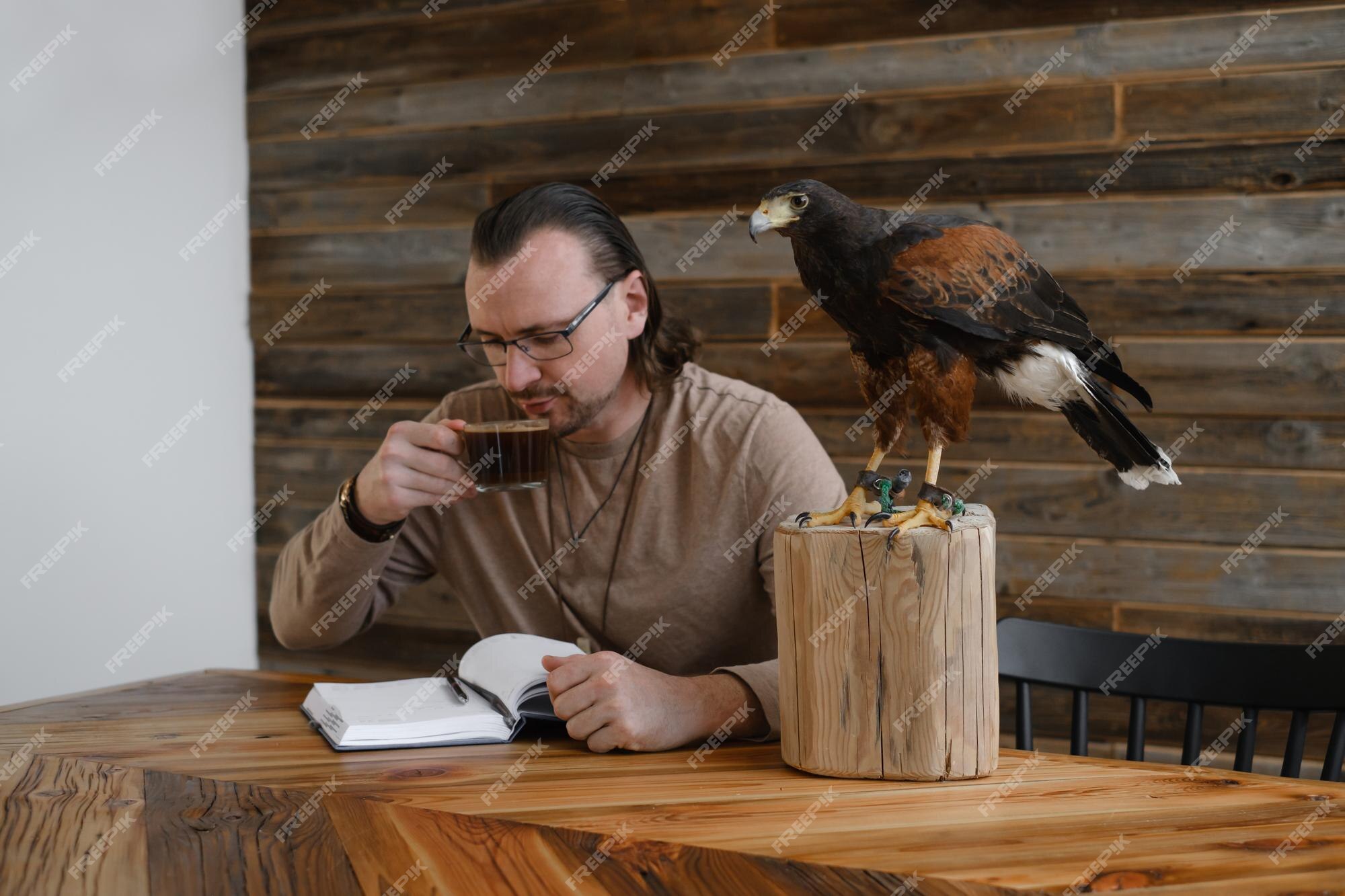 El hombre está trabajando escribiendo con un pájaro águila salvaje | Foto  Premium