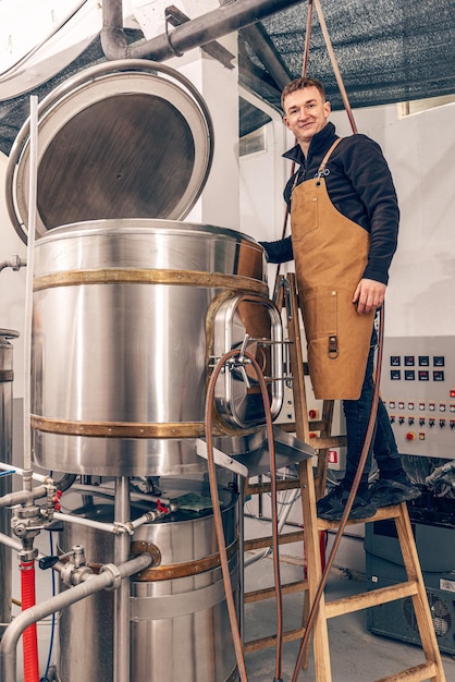 Foto el hombre está trabajando en la fábrica de cerveza artesanal