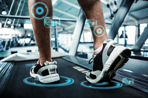 Hombre trabajando en el gimnasio contra la interfaz de fitness