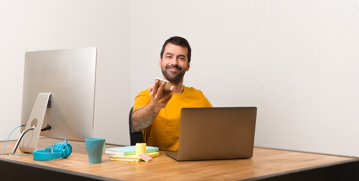 Foto hombre trabajando con laptot en una oficina hablando con el móvil