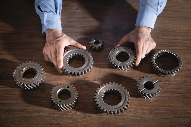 Hombre trabajando con ruedas dentadas de metal