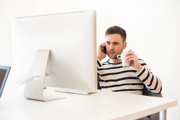 Hombre trabajando y usando teléfono móvil en la oficina