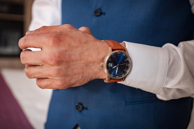 Foto hombre de traje azul ajustando su reloj