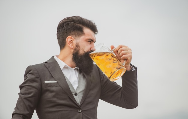 Hombre en traje clásico bebiendo cerveza Retrato de hombre con una gran taza de cerveza