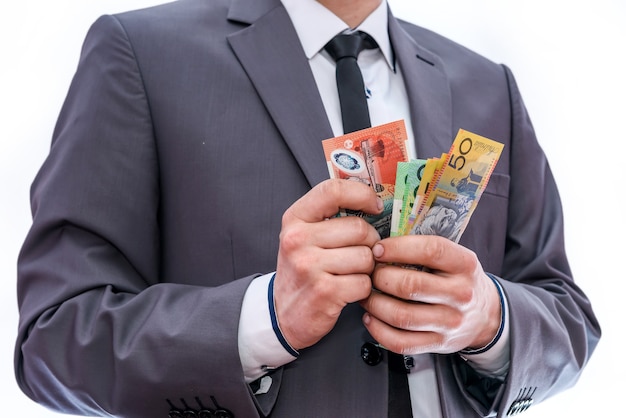 Hombre en traje contando coloridos dólares australianos