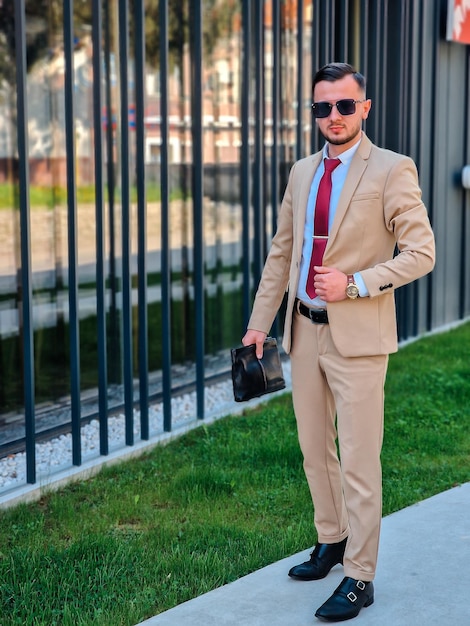 Un hombre con traje y corbata se para en una acera.