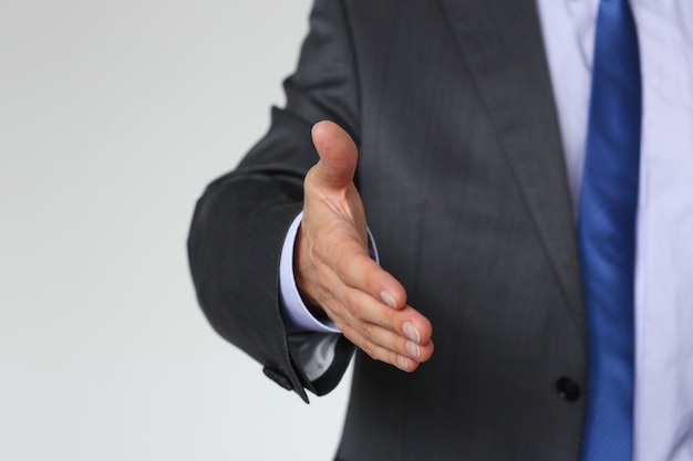 Hombre en traje y corbata dan la mano como hola en la oficina