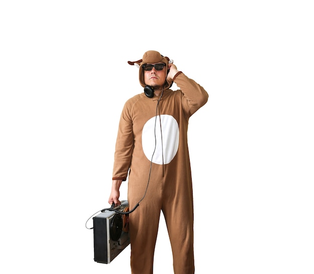 Hombre en traje de cosplay de una vaca con grabadora de carrete. Chico en la ropa de dormir de pijama de animales. Foto divertida con ideas para fiestas. Música disco retro.