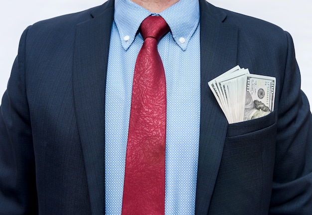 Hombre de traje con dólares en el bolsillo aislado en blanco