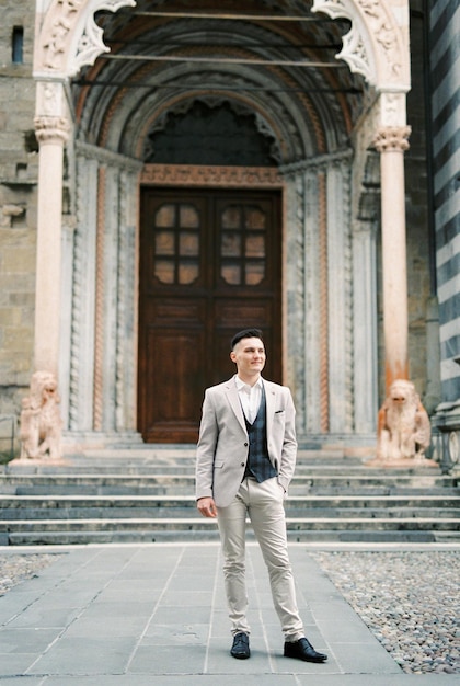 El hombre de traje se encuentra frente a la entrada de la iglesia Bérgamo Italia