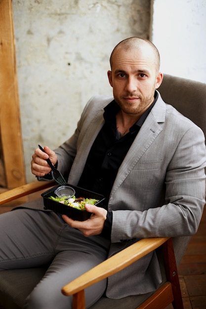 Un hombre de traje está almorzando. Entrega de comida