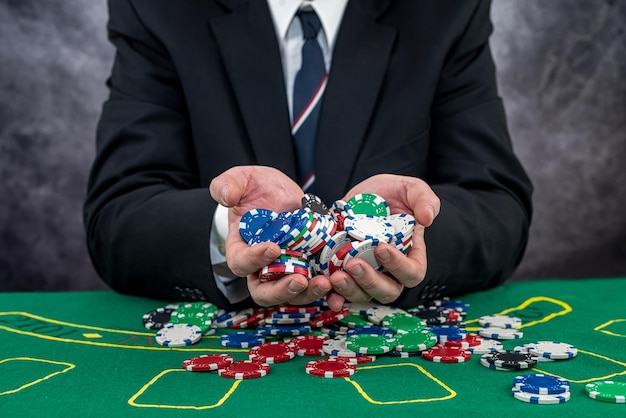 Hombre de traje con fichas de póquer jugando en el casino Concepto de juego