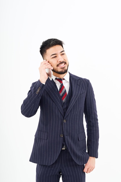 Un hombre con traje hablando por un teléfono inteligente