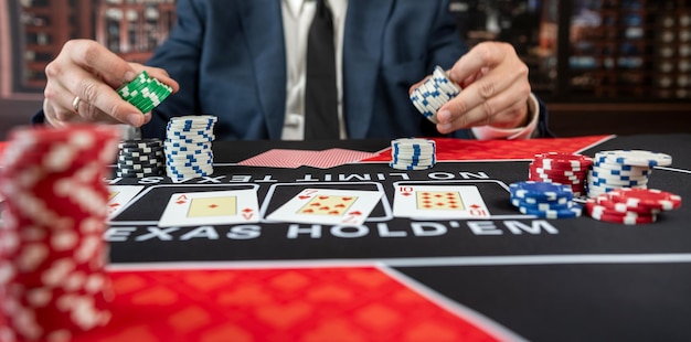 hombre con traje jugando al póquer en la mesa del casino ganando el Royal Flush en el casino concepto de juego