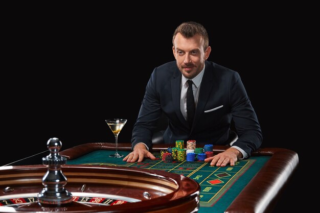 Hombre de traje jugando a la ruleta. adicción al juego.