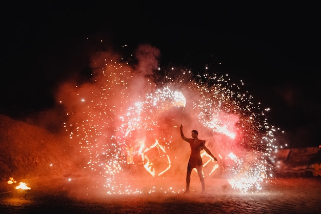 Un hombre con traje LED baila con noche de fuego