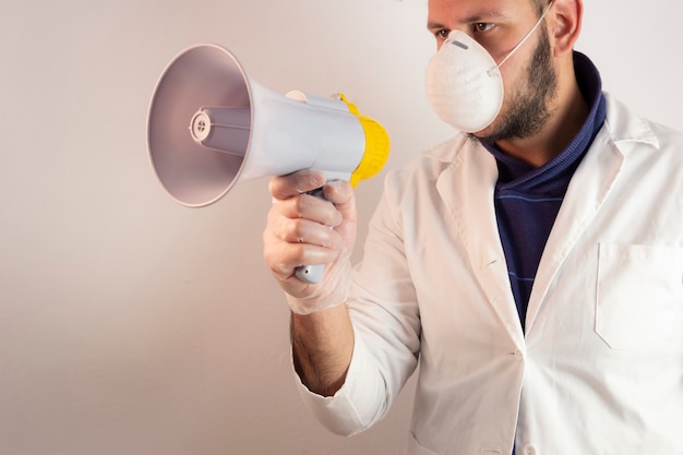 Hombre en traje de médico con un megáfono