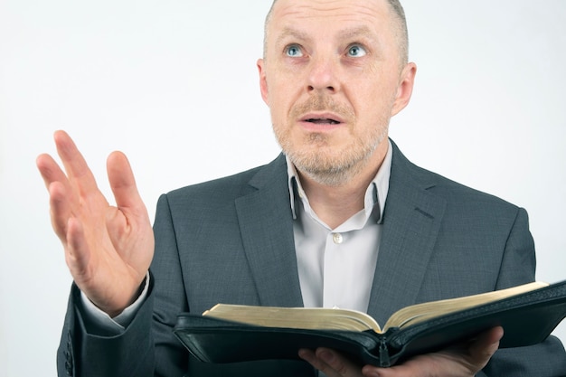 El hombre en un traje de negocios está leyendo la Biblia.