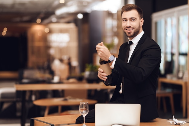 Un hombre en un traje de negocios está sosteniendo una botella de vino.