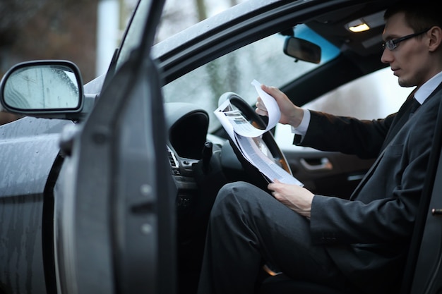 Foto el hombre en traje de negocios está sentado en el auto