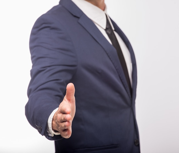 Foto hombre de traje con la palma abierta para saludar a alguien.