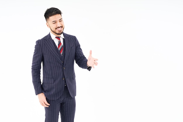 Un hombre de traje pidiendo un apretón de manos.