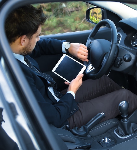 Hombre en un traje de pie en un auto