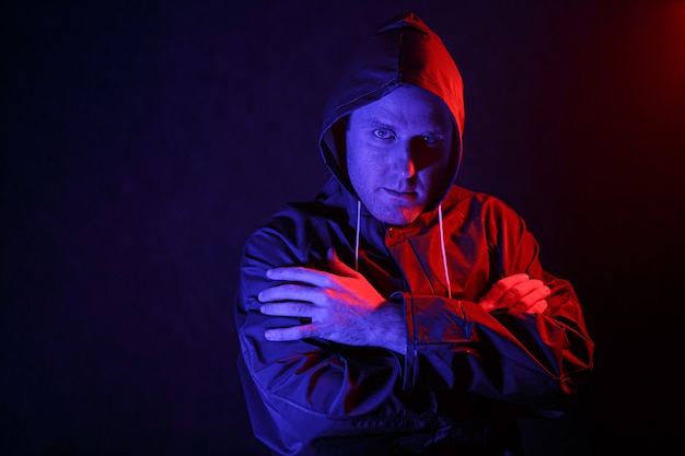 Un hombre con traje de protección en una habitación oscura. Concepto de imagen de Halloween. Protección de virus. Iluminado con luces de colores