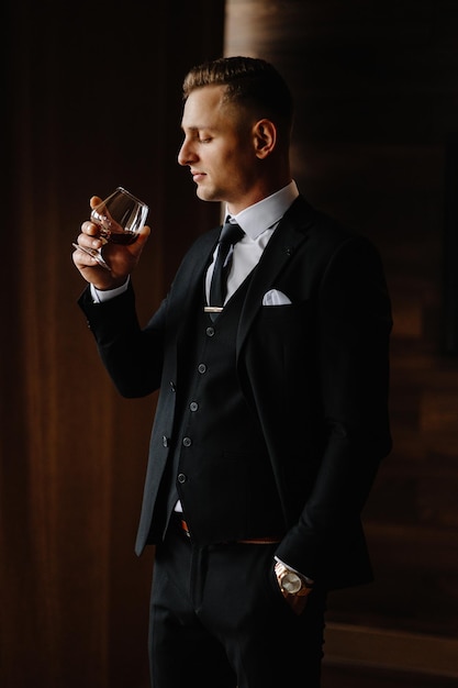 Foto un hombre en traje está sosteniendo un vaso de vino