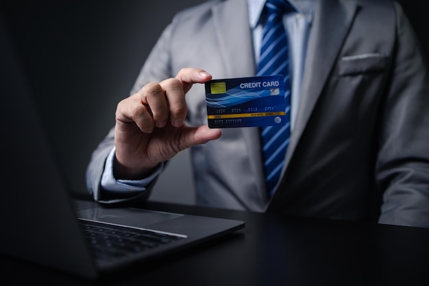 Hombre de traje con tarjeta de crédito empresario tiene tarjeta de crédito usando tarjeta de crédito para pagar bienes y servicios en la tienda compras en línea en el sitio web y pago con tarjeta de crédito Concepto de compras en línea